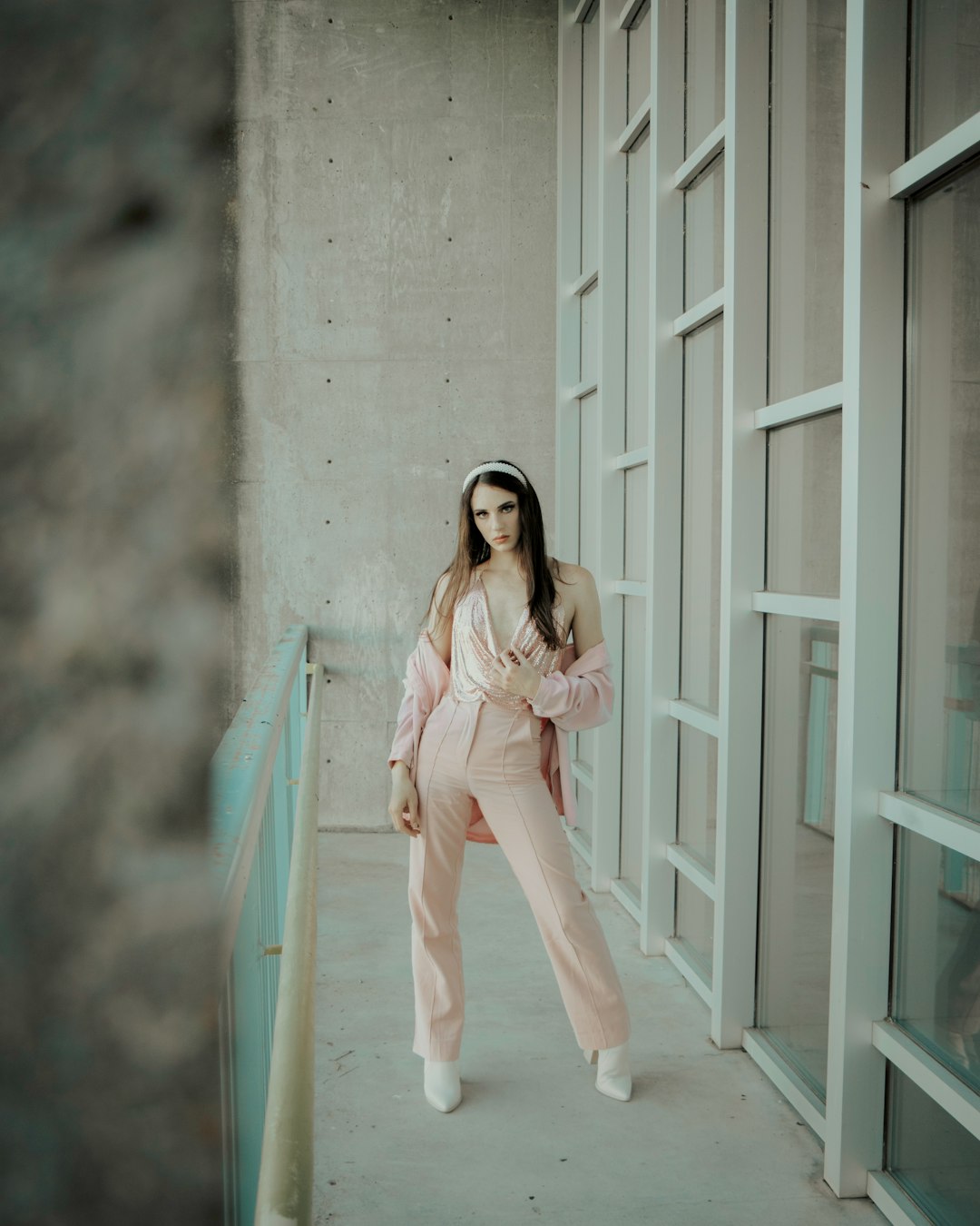 woman in pink long sleeve shirt and white pants standing on white wooden floor