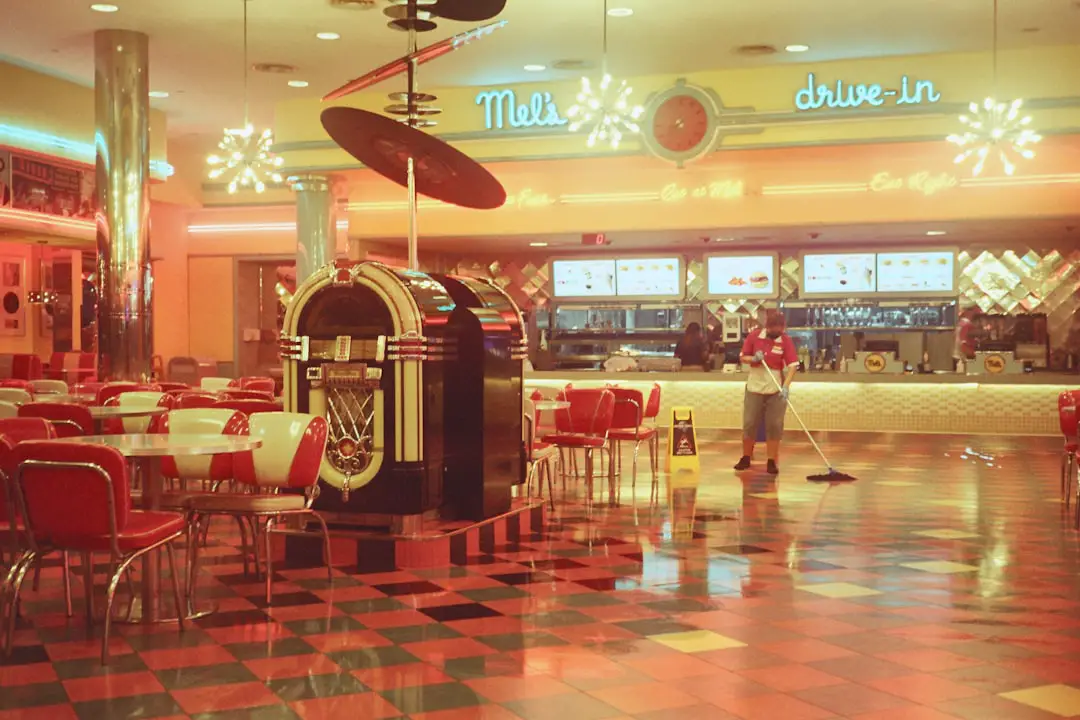 A restaurant with a checkered floor and red chairs