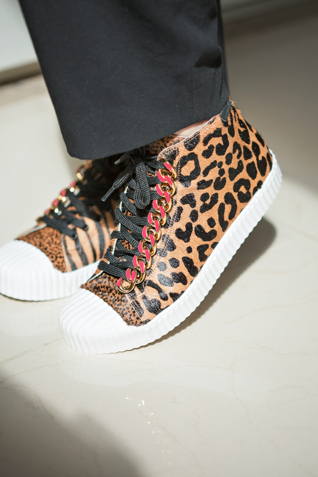 a close up of a person wearing leopard print sneakers
