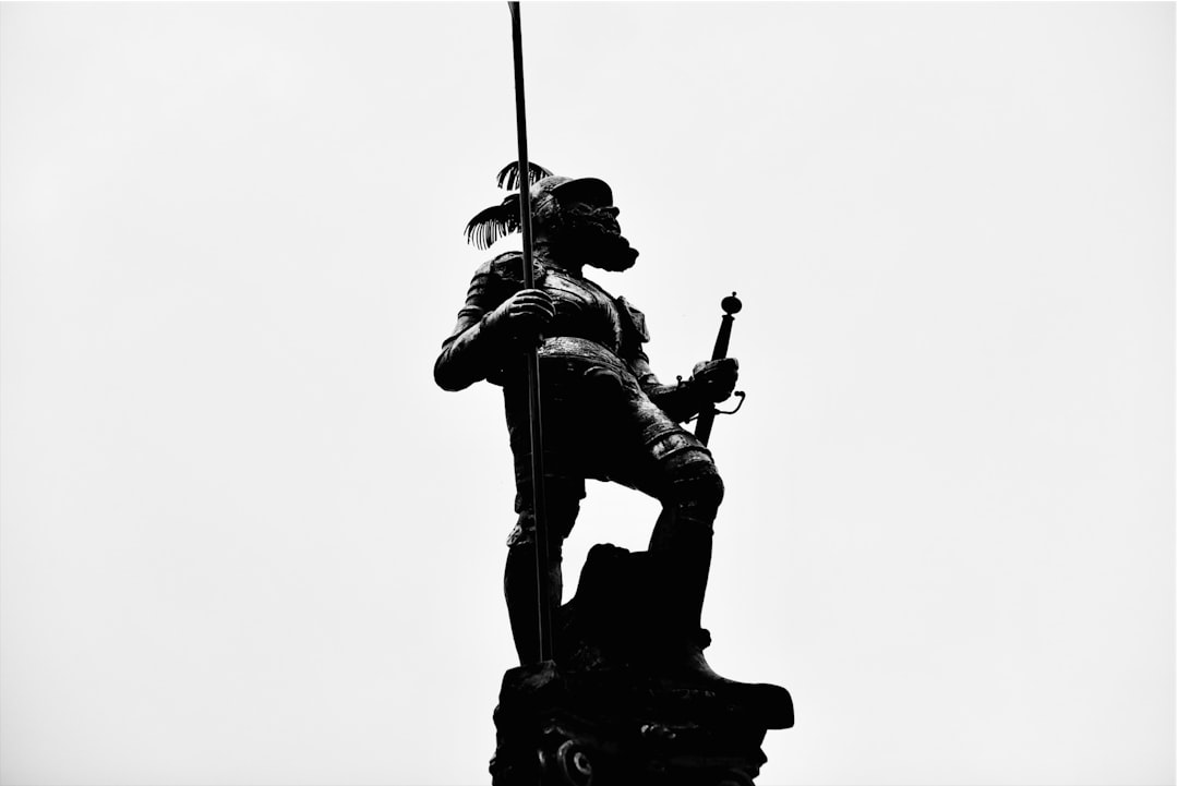 A black and white photo of a statue of a man holding a rifle