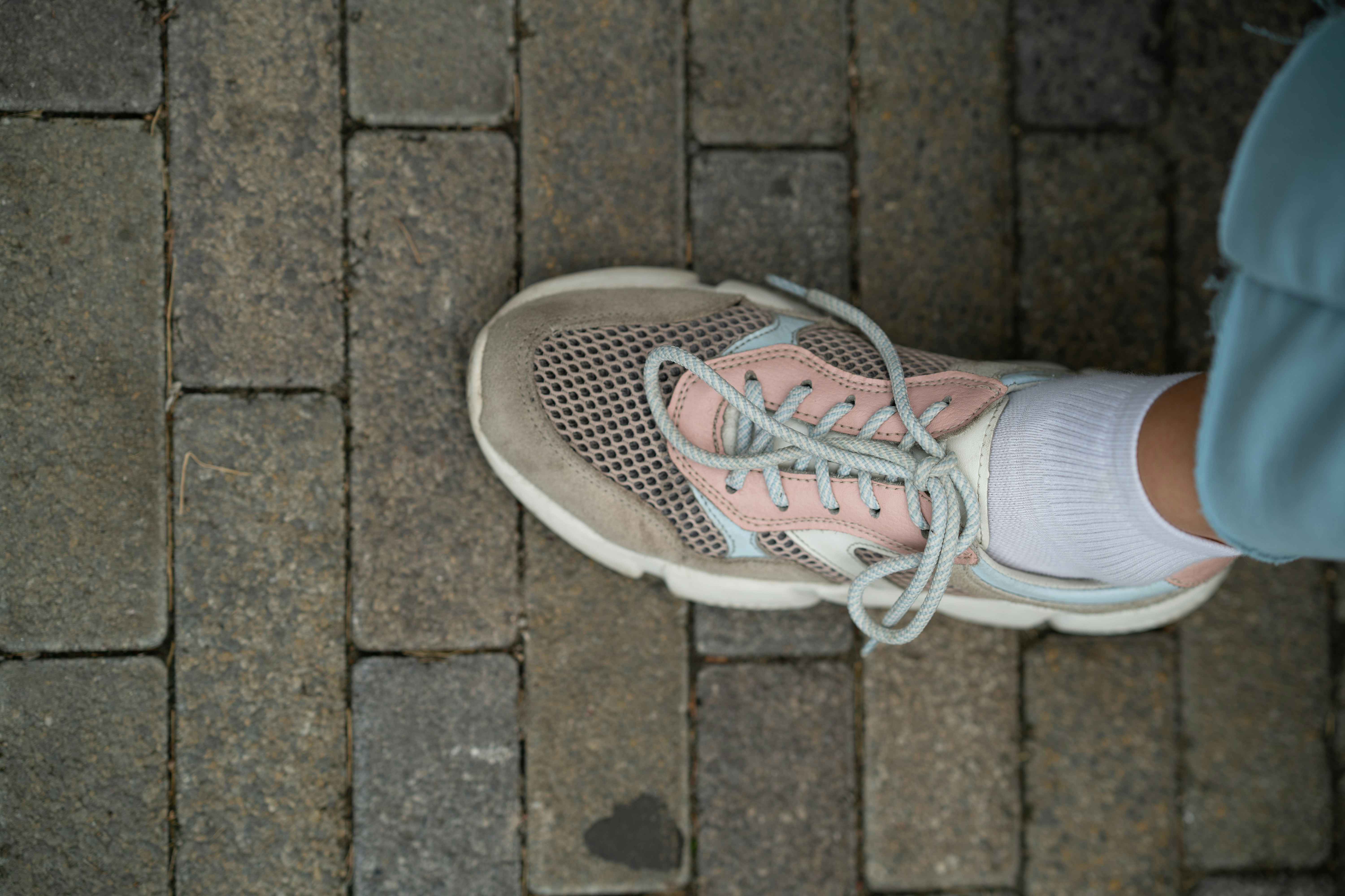 a person standing on a brick walkway with their shoes on