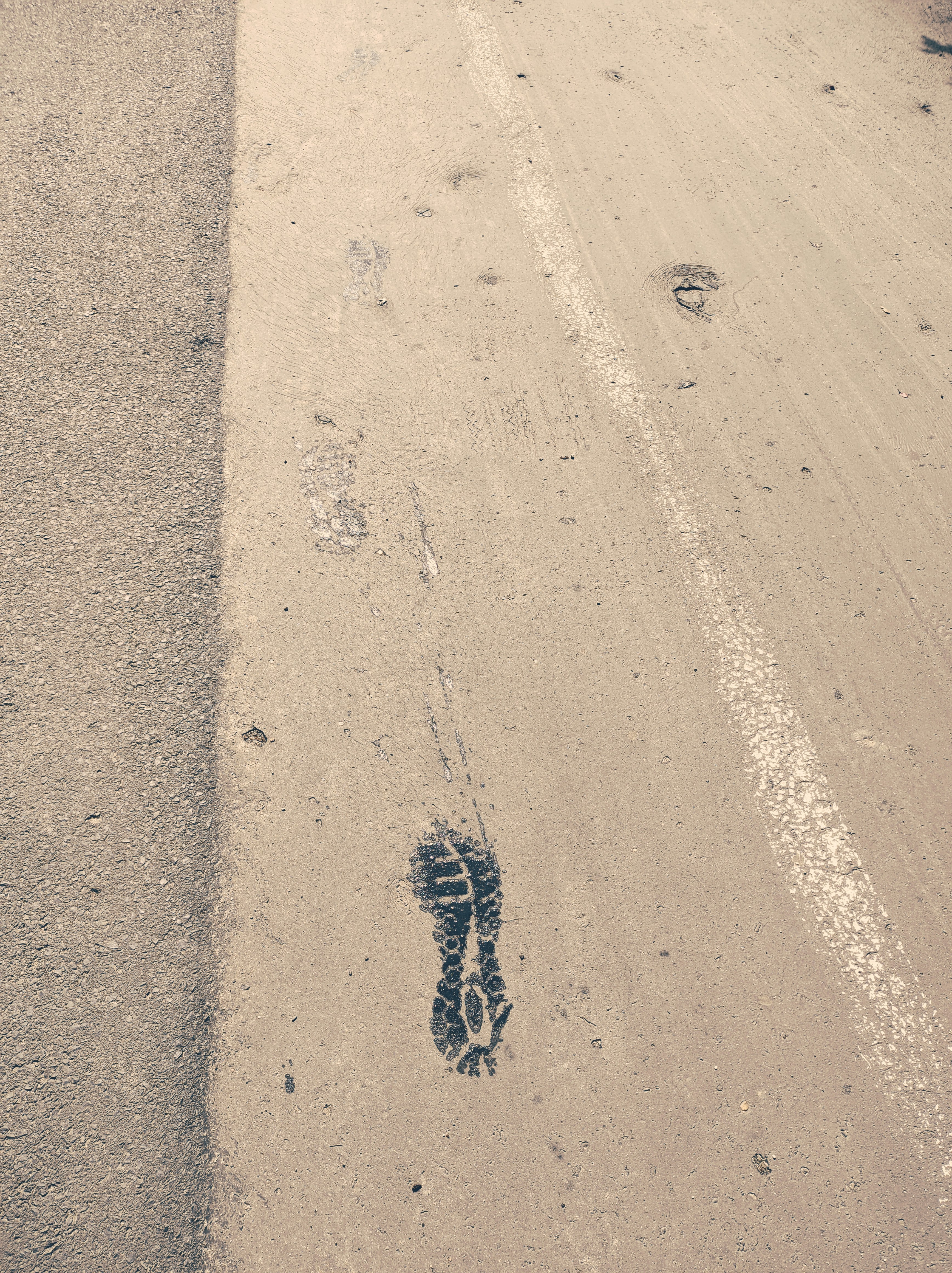 A person walking down a street next to a traffic light